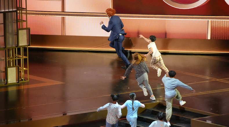 Host Conan O'Brien, dressed as the character Gladys Lilly from "Weapons" is chased by children during the Oscars on Sunday, March 15, 2026, at the Dolby Theatre in Los Angeles. (AP Photo/Chris Pizzello)