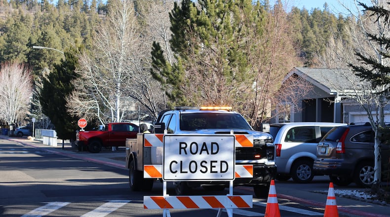 The blocked road to a neighborhood in Flagstaff, Arizona, where police say a man opened fire at officers is seen Thursday, Feb. 5, 2026. (AP Photo/Cheyanne Mumphrey)