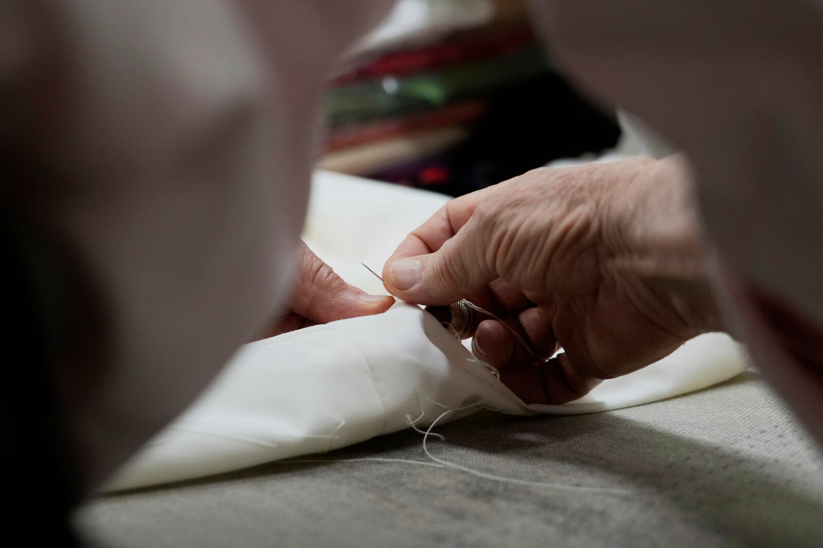Italian tailor Raniero Mancinelli. who on his own initiative is making outfits for a possible future Pope, works on a pontiff's robe inside his shop in Rome, Wednesday, April 30, 2025. (AP Photo/Gregorio Borgia)