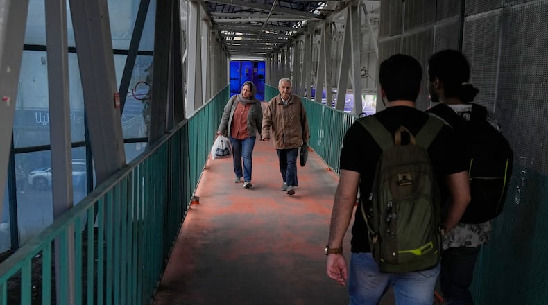 People walk across an overpass in downtown Tehran, Iran, Tuesday, Feb. 24, 2026. (AP Photo/Vahid Salemi)