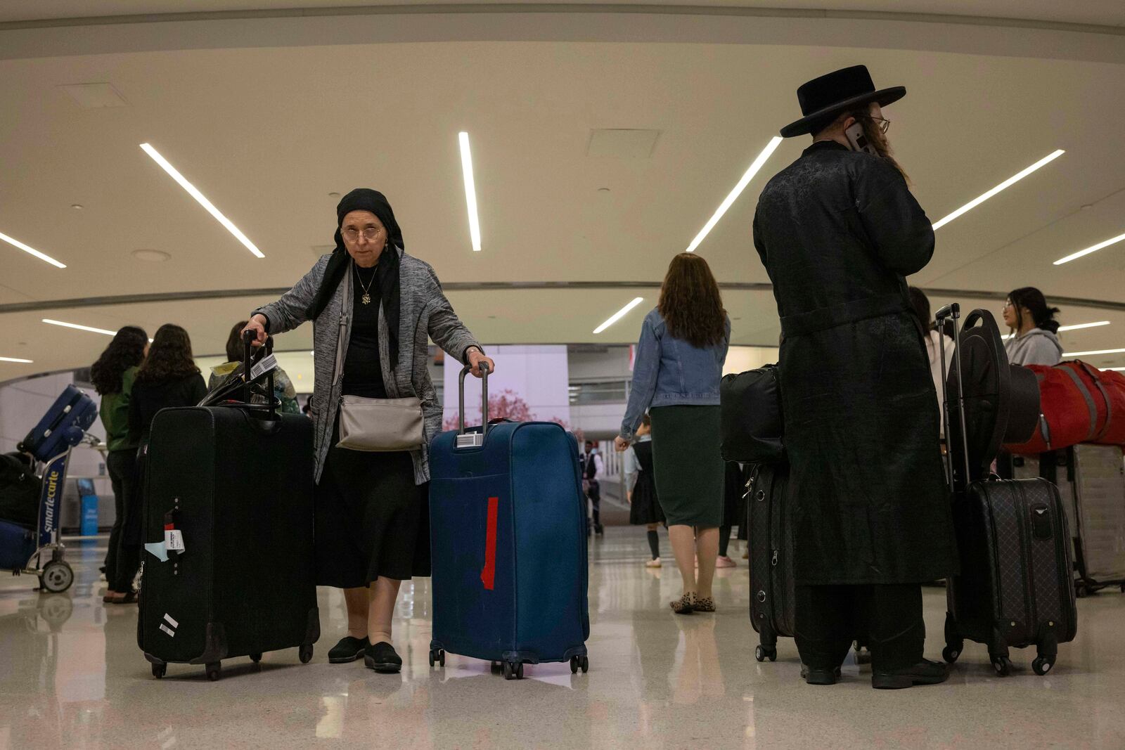 People carrying suitcase arrive from international flight at Newark Liberty International Airport, Monday, June 9, 2025, in New Jersey. (AP Photo/Yuki Iwamura)