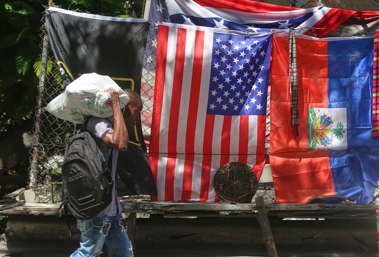A man walks past a vendor's stall selling U.S. and Haitian flags in Port-au-Prince, Haiti, Thursday, June 5, 2025. (AP Photo/Odelyn Joseph)