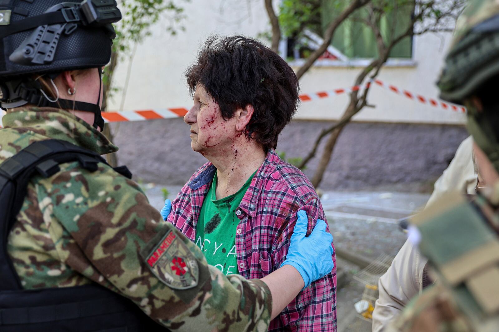 A police officer comforts an injured woman near a multi-storey building damaged by a Russian strike on residential neighbourhood in Zaporizhzhia, Ukraine, on Tuesday, April 22, 2025. (AP Photo/Kateryna Klochko)