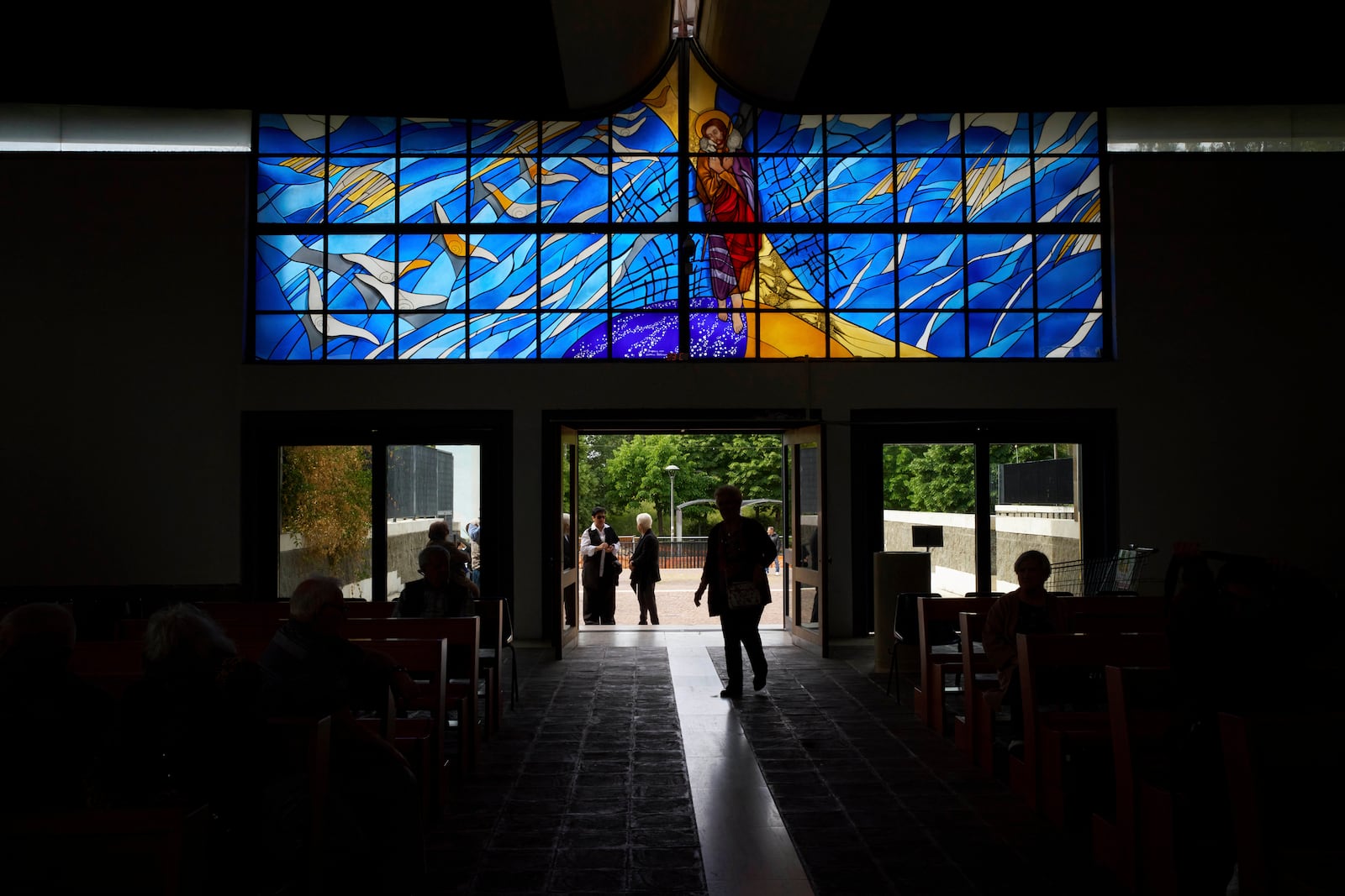Faithful enter for a mass in San Paolo Della Croce parish church in Corviale neighbourhood, in Rome, Sunday, May 4, 2025. (AP Photo/Alessandra Tarantino)