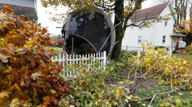 Tree limbs and a trampoline litter a front yard along East Street in South Vienna after they were blown from a neighbors back yard across the street. Bill Lackey/Staff