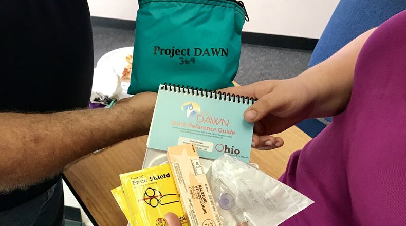 Steve Prether and his daughter, Brianna, examine the inside of a Narcan kit at the Conversation for Change program in Springfield earlier this year. STAFF PHOTO/MICHAEL COOPER