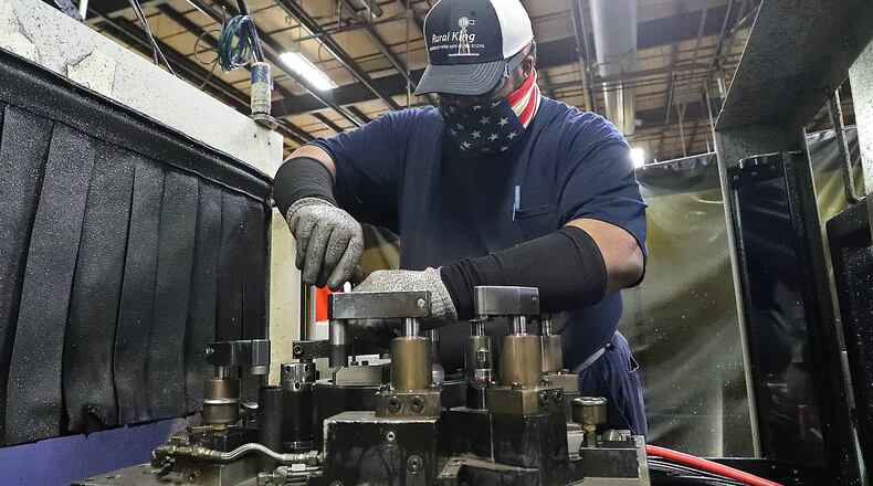 Chris Martin changes the chuck in a a precision drilling machine at Pentaflex. BILL LACKEY/STAFF