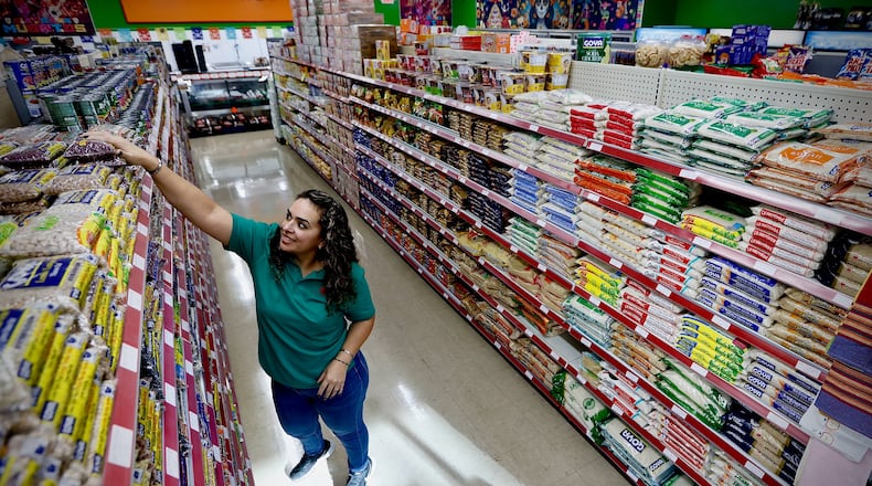 Manager Anita Gutierrez stocks the shelves at Springfield's second Adasa Latin Market, which will host a grand opening celebration on Friday, Nov. 1, at 1574 Lagonda Ave. Saul Buitron, who helps run the supermarket with his wife and owner, Alicia Mercado, said they decided to open a second location because of the Latino population. Marshall Gorby/Staff Photo