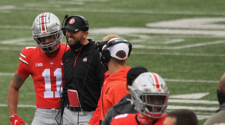 Ohio State wide receiver Jaxon Smith-Njigba celebrates a touchdown with coach Brian Hartline against Nebraska on Saturday, Oct. 24, 2020, at Ohio Stadium in Columbus. David Jablonski/Staff