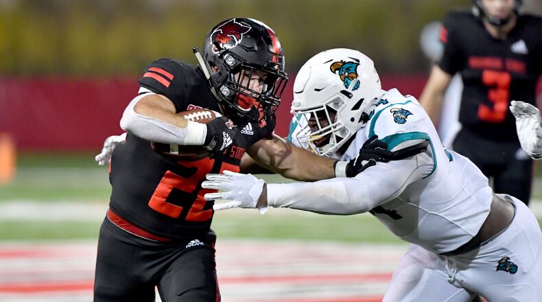 Arkansas State running back Lincoln Pare (22) tries to get past Coastal Carolina defender Jeffrey Gunter (94) during the second half of an NCAA college football game Thursday, Oct. 7, 2021, in Jonesboro, Ark. (AP Photo/Michael Woods)