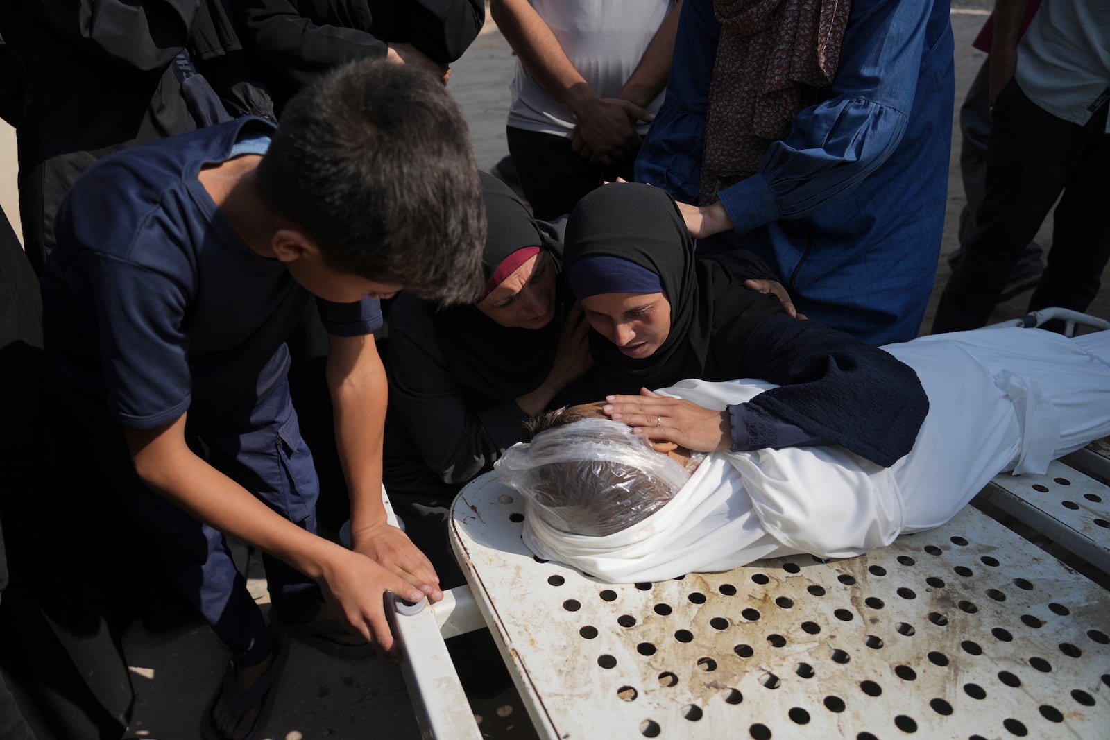 Relatives of Palestinian child Salem Hussein, 12, killed in an Israeli army bombardment of Gaza, mourn beside his body at Shifa Hospital in Gaza City on Tuesday, July 22, 2025. (AP Photo/Jehad Alshrafi)