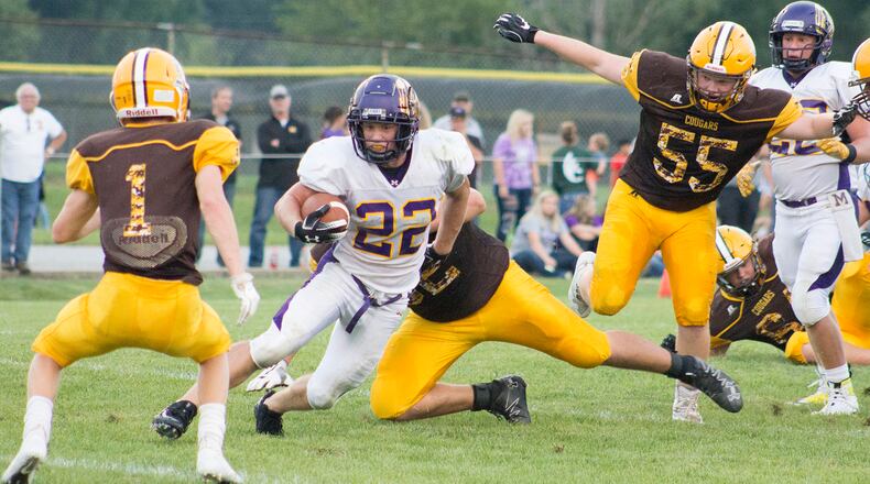 Mechanicsburg’s Joey Mascadri runs through a hole in the Kenton Ridge defense toward Andrew Good, 1, and away from Brandon Collins, 55, during a game at Kenton Ridge earlier this season. Jeff Gilbert/CONTRIBUTED