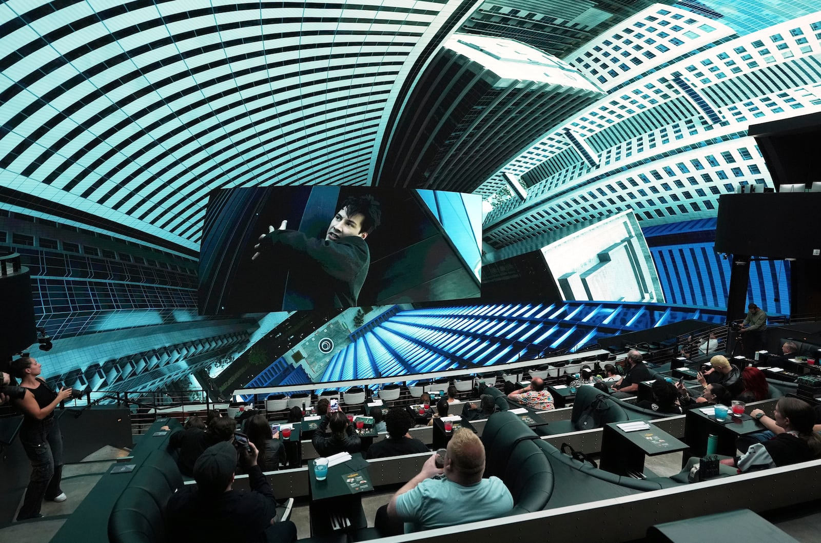 A scene from the film "The Matrix" is surrounded by immersive urban visuals during a screening of "The Matrix in Shared Reality" on Wednesday, May 28, 2025, at Cosm Los Angeles in Inglewood, Calif. (AP Photo/Chris Pizzello)
