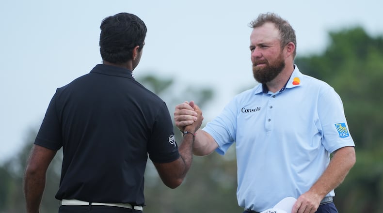 Shane Lowry of Ireland shakes hands with Aaron Rai of England, at the end of the third round of the Cognizant Classic golf tournament, Saturday, Feb. 28, 2026, in Palm Beach Gardens, Fla. (AP Photo/Marta Lavandier)