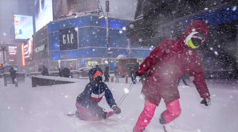 Hannah and Astrid Grimskog play in Times Square during a snow storm, Monday, Feb. 23, 2026, in New York. (AP Photo/Seth Wenig)