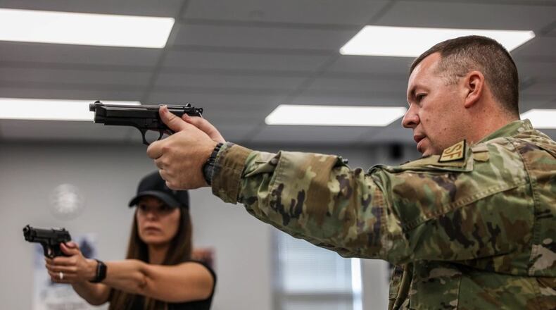 Senior Master Sgt. Jason Mufford, 445th Security Forces Squadron combat arms NCO in charge, provides small arms training for Ann McCaslin at Wright-Patterson Air Force Base, in August 2023. (U.S. Air Force photo by Master Sgt. Patrick OReilly)