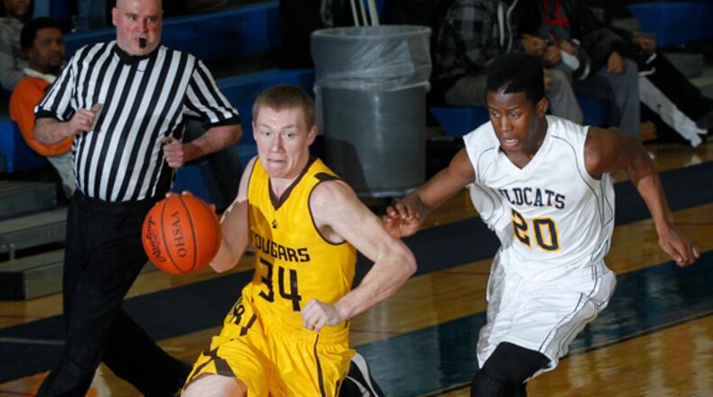 Jonah Colvin (34) of Kenton Ridge is guarded by Derick Yarbrough (20) of Springfield during Tuesday's basketball game at Springfield on February 12, 2013. Springfield won the game 58-44. Barbara J. Perenic/Staff