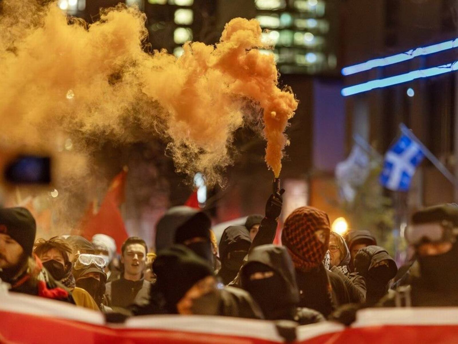 A protester holds a smoke torch in Montreal during protests against the NATO Parliamentary Assembly in November 2024.