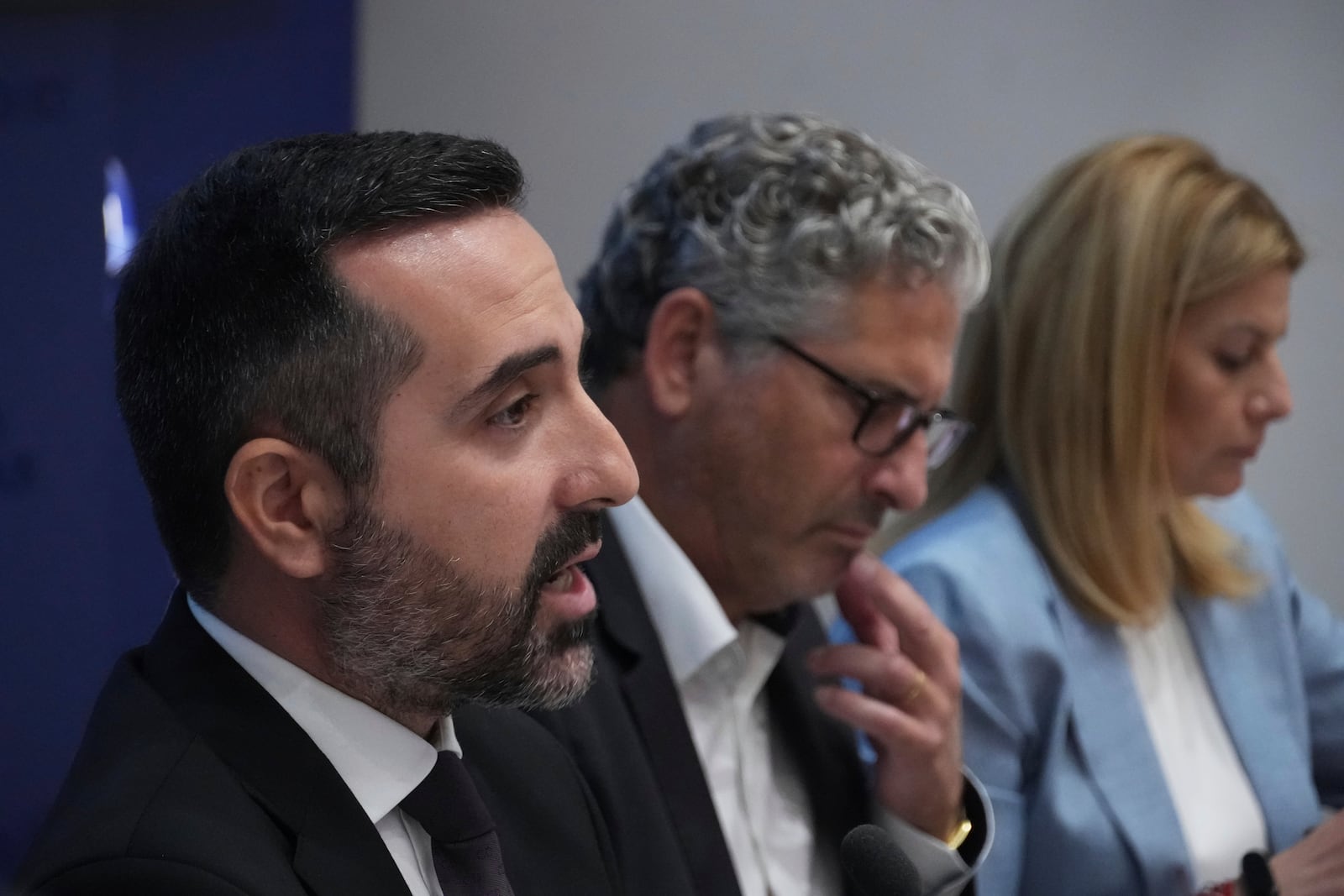 Cyprus' deputy minister for migration Nicholas Ioannides, left, explains how a new voluntary repatriation program for Syrian families living in Cyprus will work during a press conference, at the Press and Informations office in the capital Nicosia, Cyprus, Thursday, May 29, 2025. (AP Photo/Petros Karadjias)