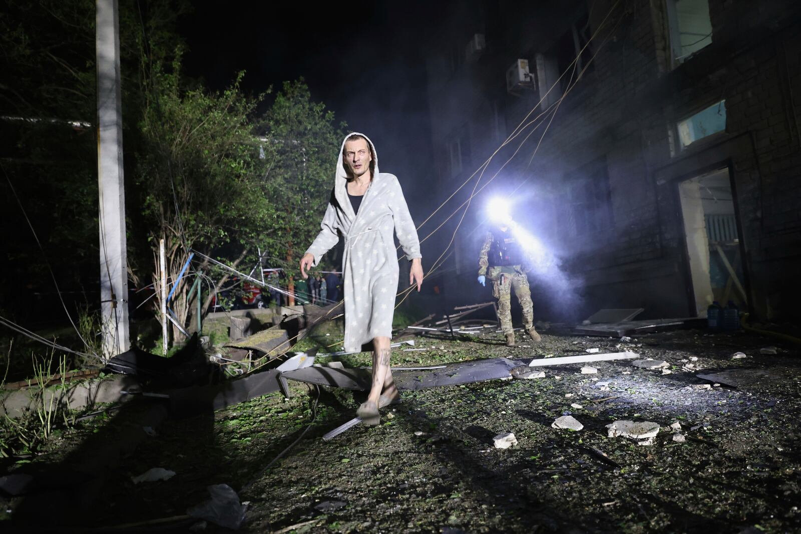 A man walks in a yard of a residential building destroyed by a Russian strike in Zaporizhzhia, Ukraine, Thursday, May 1, 2025. (AP Photo/Kateryna Klochko)