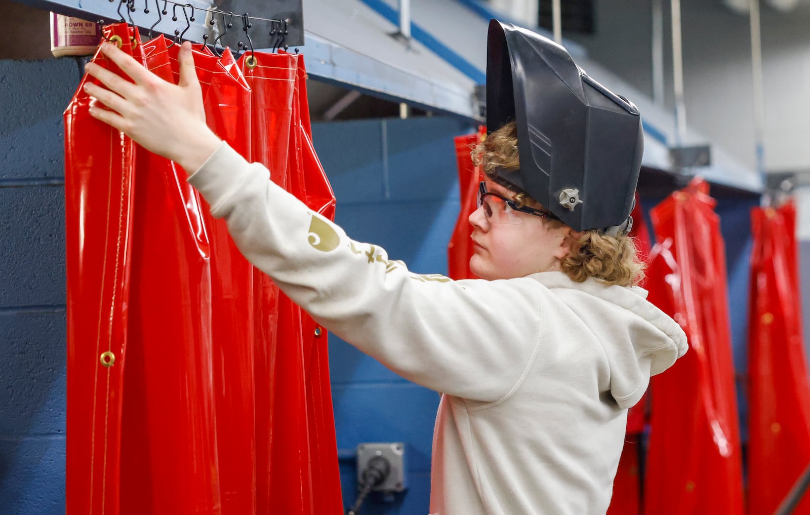 Mason Craycraft, a sophomore at the School of Innovation, arranges curtains in the welding lab during a tour as part of "The Dome Experience" at the Dome on Wednesday, March 25, 2026, in Springfield. JOSEPH COOKE/STAFF