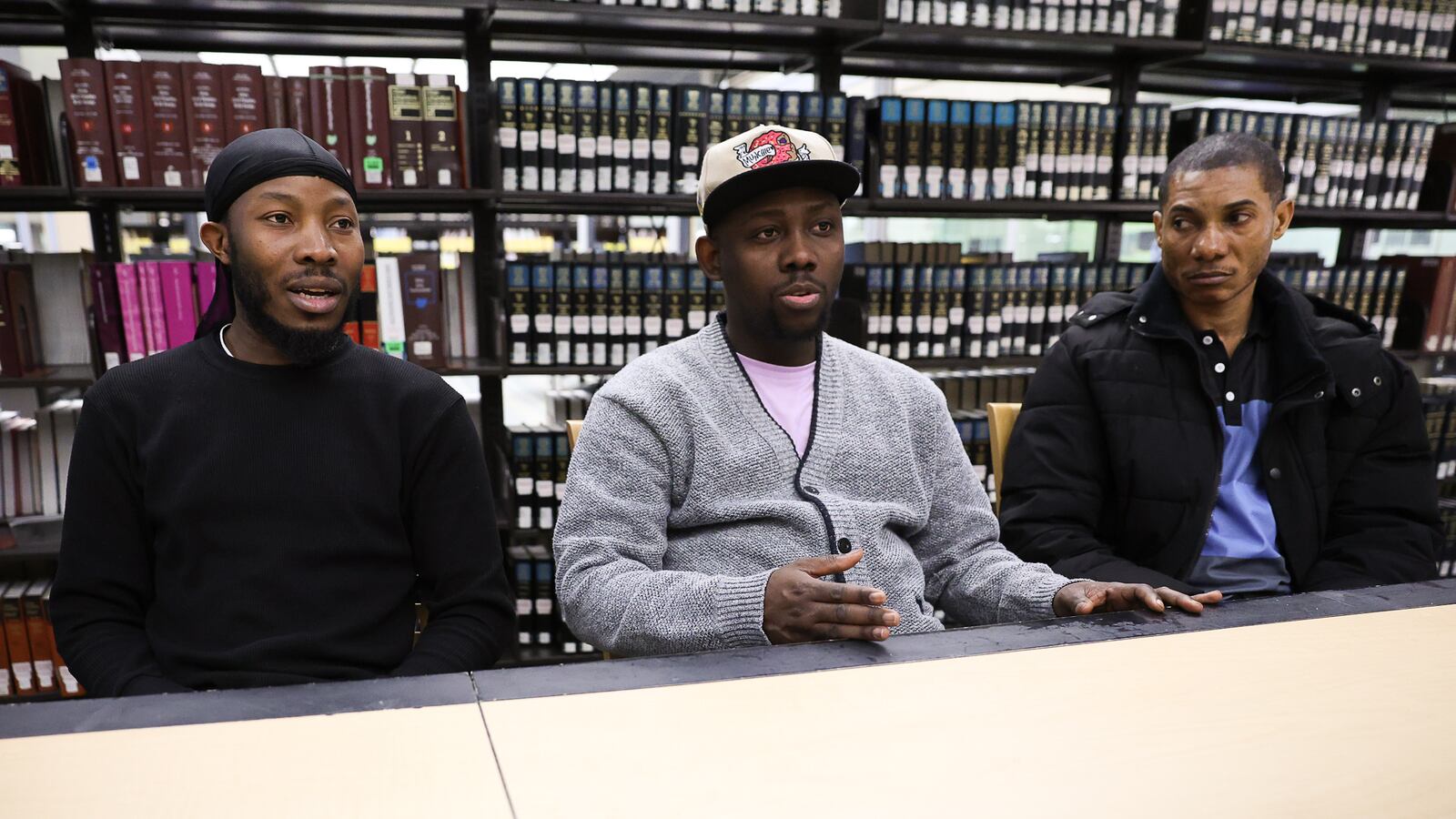 Roudechel Charpentier (left) and Wesley Joseph (center) talk as Jean Roma Barthelemy (right) listens during an interview on March 28 at Sinclair Community College. The three are among thousands of Haitian immigrants in the region facing uncertain futures. BRYANT BILLING / STAFF