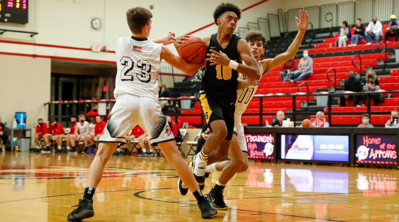 Braves1: Shawnee High School senior Jamon Miller drives through Tecumseh's Collin O'Connor (23) and Brendan Toops (11) during their game on Friday night at Reynolds Gym in New Carlisle. The Braves won 69-53. Michael Cooper/CONTRIBUTED
