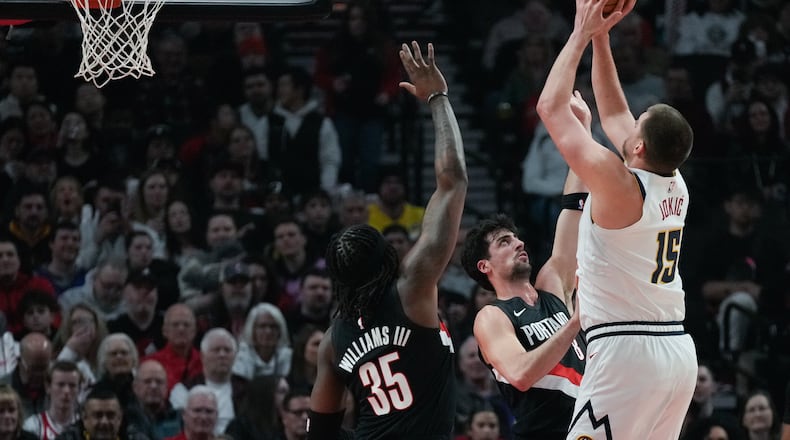 Portland Trail Blazers forward Deni Avdija (8) tries to block a shot by Denver Nuggets center Nikola Jokić (15) during the first half of an NBA basketball game Friday, Feb. 20, 2026, in Portland, Ore. (AP Photo/Jenny Kane)