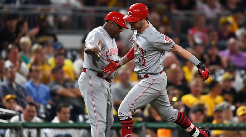 Reds rookie outfielder Jesse Winker celebrates his solo home run with third base coach Billy Hatcher during the seventh inning against the Pirates at PNC Park on Wednesday night.