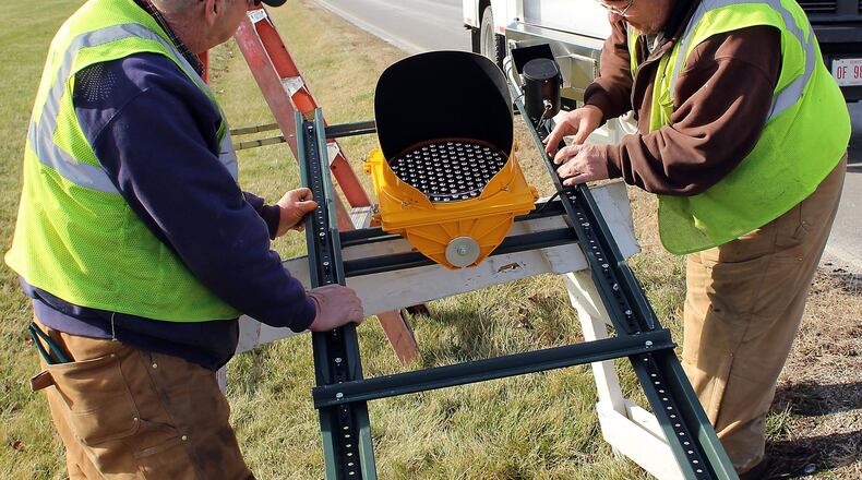 Clark County Engineer’s Department employees, (right) Keith Yeary and Tom Smith install a traffic sign to warn motorists to slow down in this 2016 photo. In 2018, Clark County employees will see insurance costs raise by about 1 percent. JEFF GUERINI/STAFF