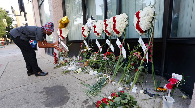 Cierra Mallory takes video of a memorial to her friend Thomas “TJ” McNichols on the sidewalk of East Fifth Street on Tuesday morning. McNichols was one of nine people gunned down early Sunday morning in the Oregon District. TY GREENLEES / STAFF