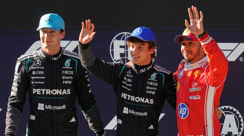Mercedes driver Andrea Kimi Antonelli of Italy, center, waves after getting the pole position beside Mercedes driver George Russell, left, of Britain and Ferrari driver Lewis Hamilton of Britain during the qualifying session of the Chinese Formula One Grand Prix at the Shanghai International Circuit, in Shanghai, China, Saturday, March 14, 2026. (AP Photo/Vincent Thian)