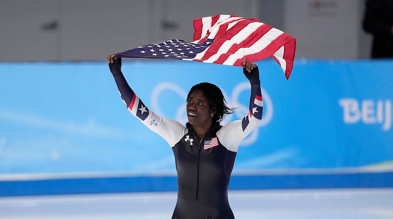 FILE - Erin Jackson of the United States hoists an American flag after winning the gold medal in the speedskating women's 500-meter race at the 2022 Winter Olympics, Sunday, Feb. 13, 2022, in Beijing. (AP Photo/Sue Ogrocki, file)
