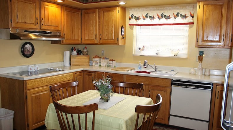The eat-in kitchen offers a U-shaped work area that boasts plenty of wood cabinetry and counter space.