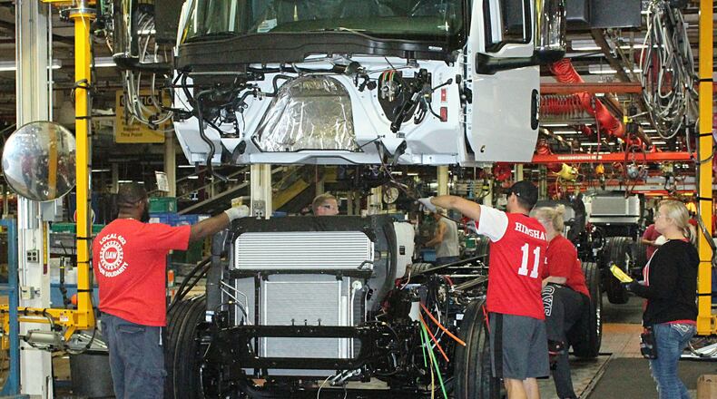 Navistar International employees put together a truck on the assembly line in a 2018 photo. JEFF GUERINI/STAFF
