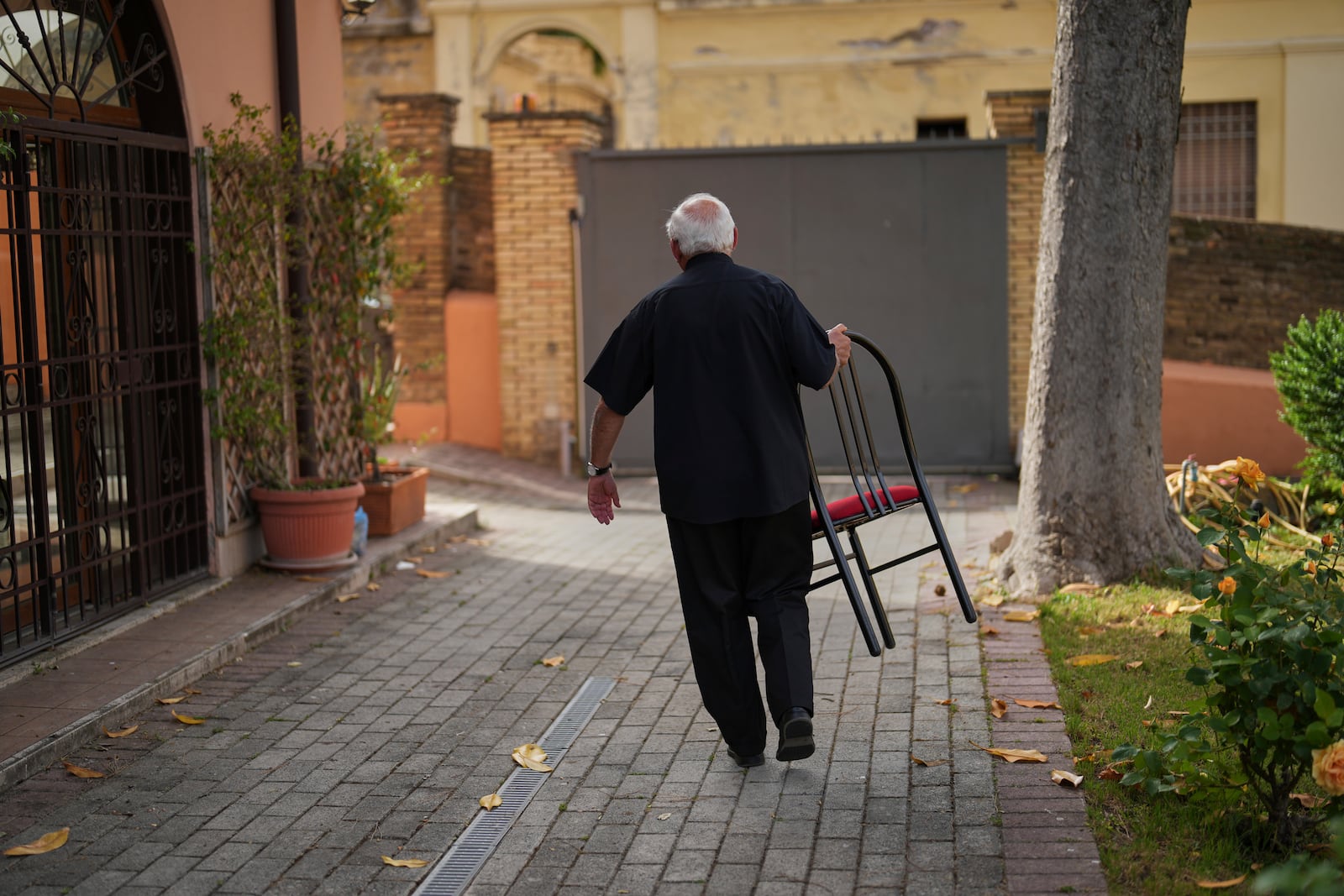 Guatemalan Cardinal Alvaro Ramazzini carries the chair he sat on, at the end of an interview with the Associated Press at the headquarters of the Scalabrinian congregation, in Rome, Saturday, May 3, 2025. (AP Photo/Francisco Seco)