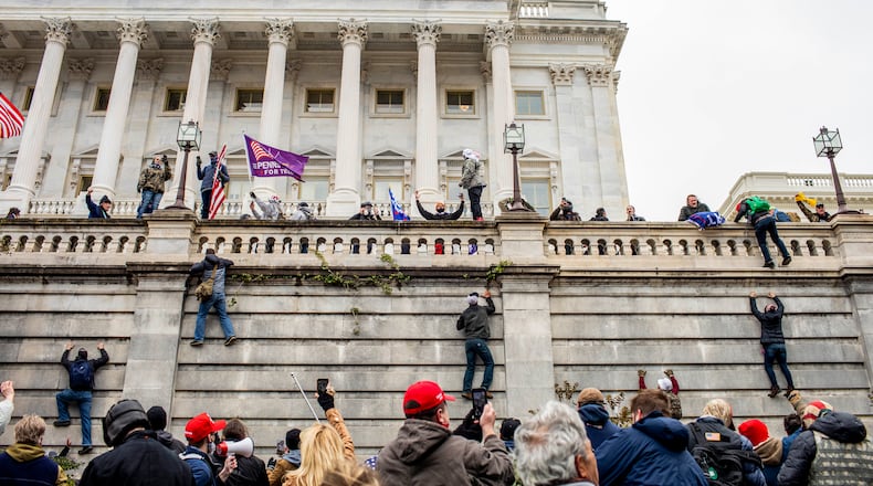 Protestors climb onto the Capitol in Washington on Wednesday, Jan. 6, 2021. A mob of people loyal to President Trump stormed the Capitol on Wednesday, halting Congress’s counting of the electoral votes to confirm President-elect Joe Biden’s victory as the police evacuated lawmakers from the building in a scene of violence, chaos and disruption that shook the core of American democracy. (Jason Andrew/The New York Times)