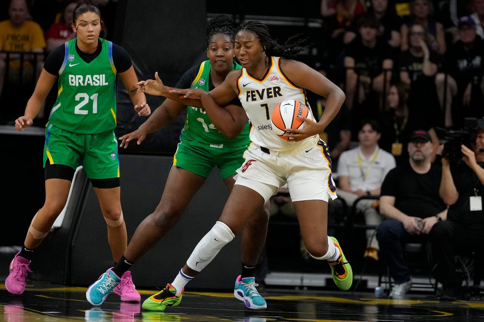 Indiana Fever center Aliyah Boston (7) drives around Brazil forward Licinara Bispo, second from left, during the first half of an exhibition women's basketball game, Sunday, May 4, 2025, in Iowa City, Iowa. (AP Photo/Charlie Neibergall)