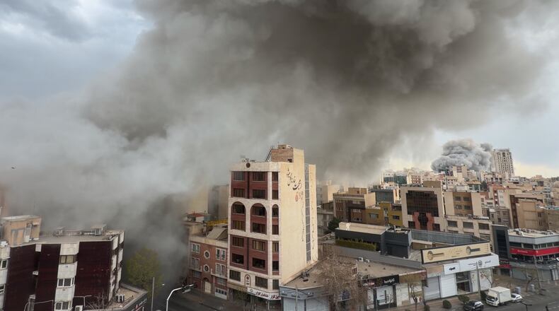 Plumes of smoke from two simultaneous strikes rise over Tehran, Iran, Monday, March 2, 2026. (AP Photo/Mohsen Ganji)