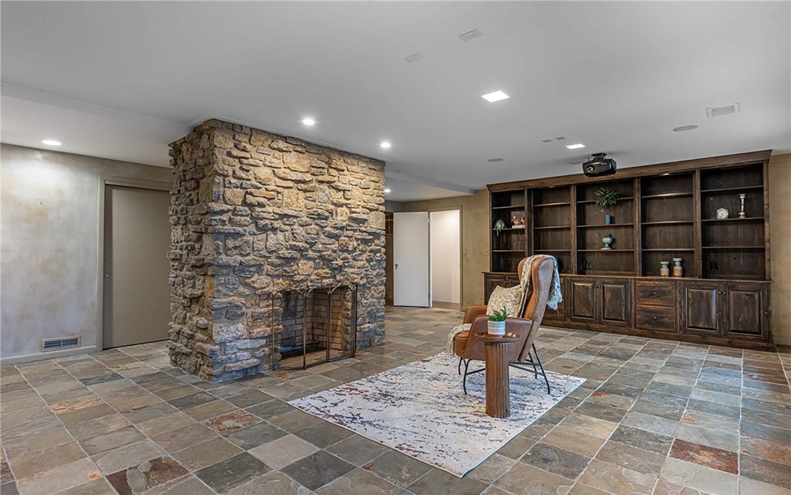 The finished walk out basement has a floor to ceiling stone fireplace, a built in entertainment center and home theater equipment. CONTRIBUTED