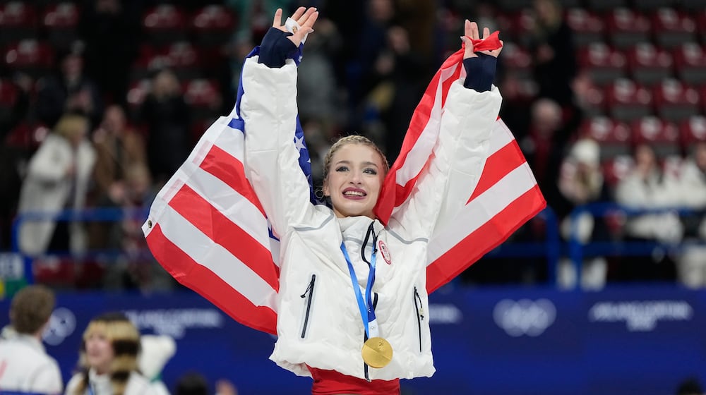 Team USA's Amber Glenn celebrates with her gold medal after the figure skating team event at the 2026 Winter Olympics, in Milan, Italy, Sunday, Feb. 8, 2026. (AP Photo/Ashley Landis)