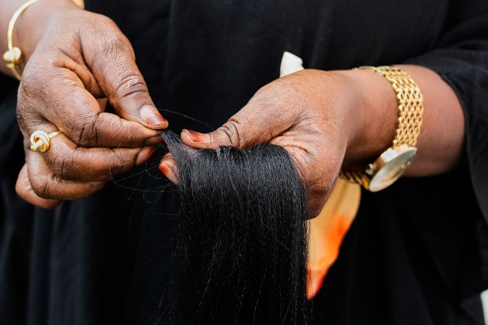 A braider separates pieces of synthetic braiding hair to prepare for a client at Eve's African Braiding in College Park, Ga., Tuesday, May 6, 2025. (AP Photo/Stephanie Scarbrough)