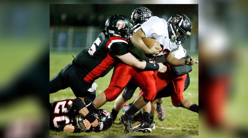 Loren Snow (22) of West Carrollton is tackled by Zeke Eier (5) and Kyle Sanning (20) of Tecumseh during Friday's first-round Division II playoff football game on Nov. 6, 2009. BARBARA J. PERENIC / STAFF PHOTO