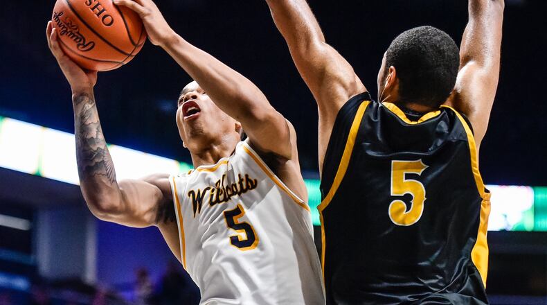 Springfield’s RaHeim Moss goes to the hoop defended by Centerville’s Mo Njie during their Division I regional boys basketball semifinal Wednesday, March 13 at Xavier University’s Cintas Center in Cincinnati. Centerville won 67-63. NICK GRAHAM/STAFF