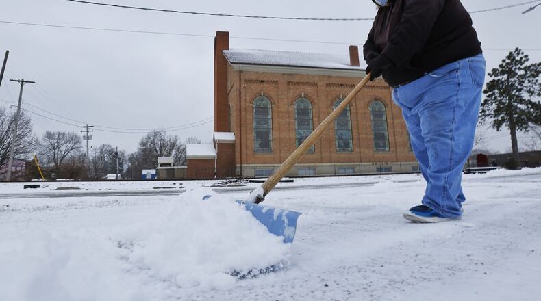 Dan Entsminger Jr. shovels snow outside D&M Tire on Front Street Monday, Jan. 17, 2022 in Hamilton. NICK GRAHAM / STAFF