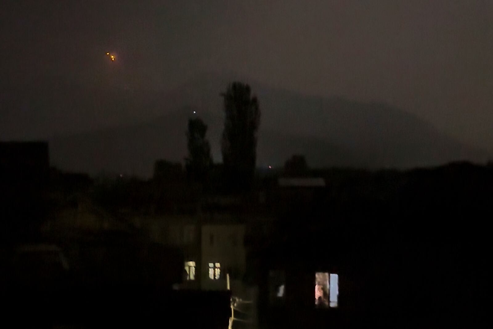 Red projectiles are seen on the horizon in Srinagar, in Indian controlled Kashmir, Saturday, May 10, 2025. (AP Photo/Mukhtar Khan)