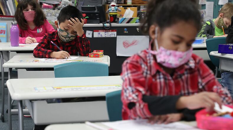 FILE PHOTO: With masks and desks spaced apart, students at Simon Kenton Elementary work on classwork Friday, Feb. 19, 2021. BILL LACKEY/STAFF
