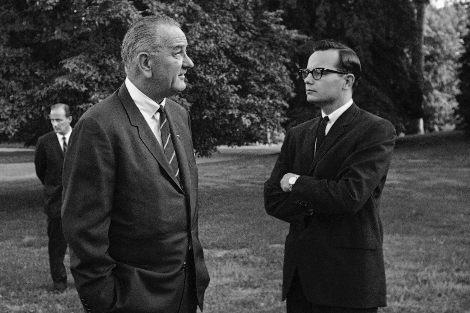 FILE - President Lyndon B. Johnson, right, talks with press secretary Bill Moyers on the South Lawn of the White House in Washington on Aug. 30, 1965. (AP Photo/William J. Smith, File)