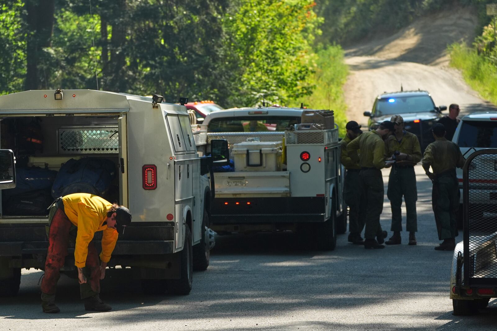 Wildland firefighters prepare gear at a staging area near the scene the day after a shooter ambushed and killed multiple firefighters responding to a wildfire at Canfield Mountain Monday, June 30, 2025, in Coeur D'Alene, Idaho. (AP Photo/Lindsey Wasson)