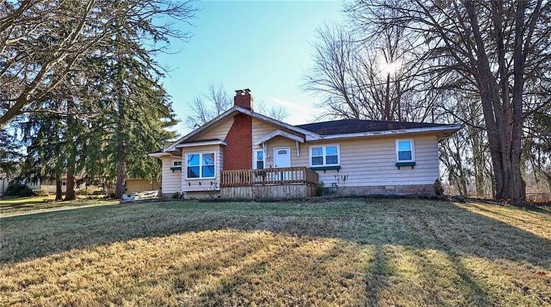 The front of the aluminum-sided home has a wooden deck with railing and an asphalt drive leading to a two-car attached garage. There is also a one-car detached garage. CONTRIBUTED PHOTOS